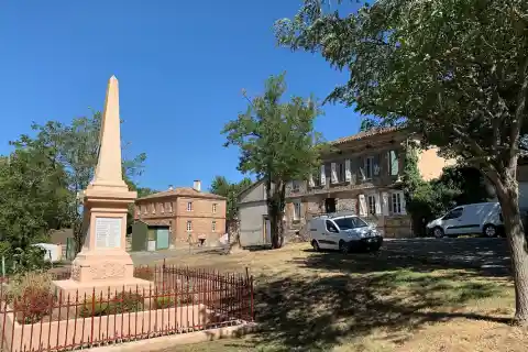 Devant l'église, la place d'Encausse dans le Gers, en France