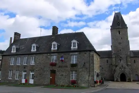 Mairie de Lonlay-l'Abbaye avec en arrière plan l'Abbaye, Orne, France