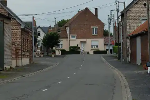 Vue de la Grand rue de Plouvain, entre l'église et le monument aux morts
